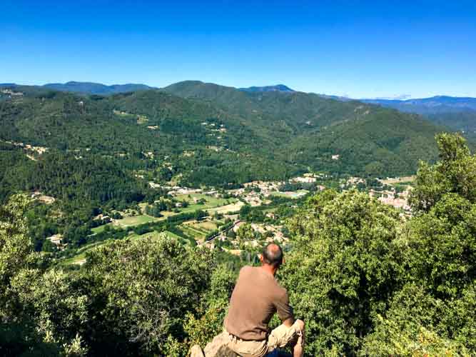 Randonneur contemplant le paysage cévenol sur le rocher d'escorce à Saint Jean du Gard